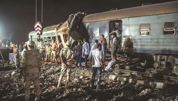 Emergency personnel and Egyptian military police search the wreckage of the train collision near Khorshid station in Alexandria late on Friday.