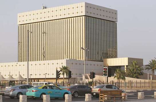 Cars drive past the Qatar Central Bank building in Doha on June 6. A higher interest rate affects the debt servicing capacity of the corporate and individual sector and may result in future erosion in asset quality, the QCB said in its 8th Financial Stability Review.