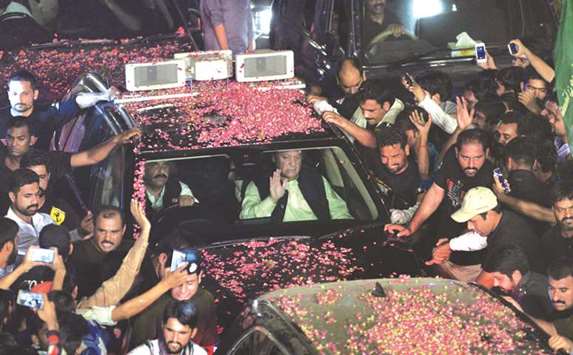 Pakistani ousted prime minister Nawaz Sharif (centre) waves as his convoy passes supporters during a rally yesterday in Lahore.