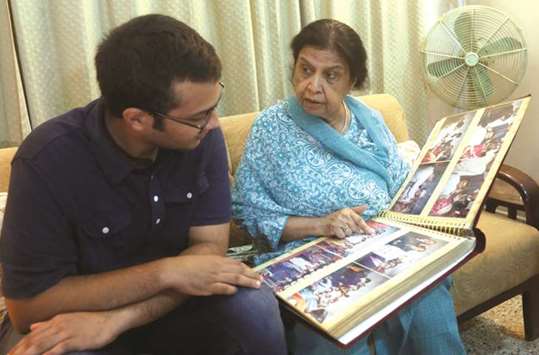 Rehana Khursheed Hashmi, 75, migrated from India with her family in 1960 and whose relatives, live in India, speaks with her grandson Zain Hashmi, 19 while looking family photo album at her residence in Karachi, Pakistan, on August 7, 2017.