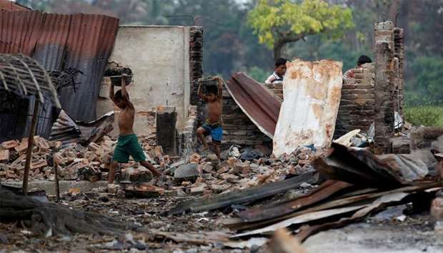 Children recycle goods from the ruins of a market which was set on fire at a Rohingya village in Rakhine