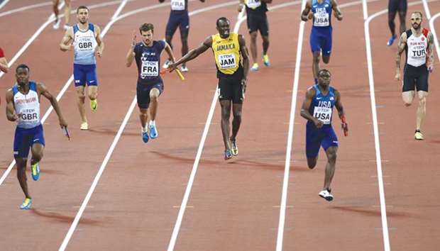 Jamaicau2019s Usain Bolt pulls up injured in the menu2019s 4x100m final as Nethaneel Mitchell-Blake (left) races to victory for Great Britain at the 2017 IAAF World Championships in London yesterday. (AFP)