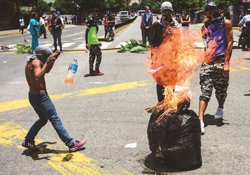 Anti-government activists demonstrate against Venezuelan President Nicolas Maduro at a barricade set up on a road in Caracas: the world watches as the Venezuelan dream becomes a nightmare.