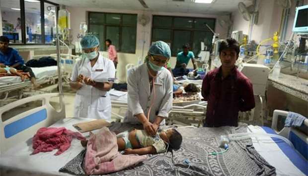 Indian medical staff attend to a child admitted in the encephalitis ward at the Baba Raghav Das Hospital in Gorakhpur, in the Uttar Pradesh state.