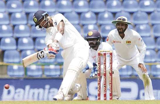 Indiau2019s Hardik Pandya (lef) plays a shot as Sri Lankau2019s Niroshan Dickwella (C) and Dimuth Karunaratne look on during the third and final Test in Pallekele. (AFP)