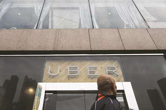 A pedestrian walks past an Uber Technologies office during a driver recruitment event in Hong Kong. The ride-services company is facing a divided board of directors and  angry shareholders after investor Benchmark Capital filed a lawsuit against the companyu2019s ousted chief executive, Travis Kalanick, dealing another blow to the firm as it struggles to recover from a series of scandals and hire a new leader.