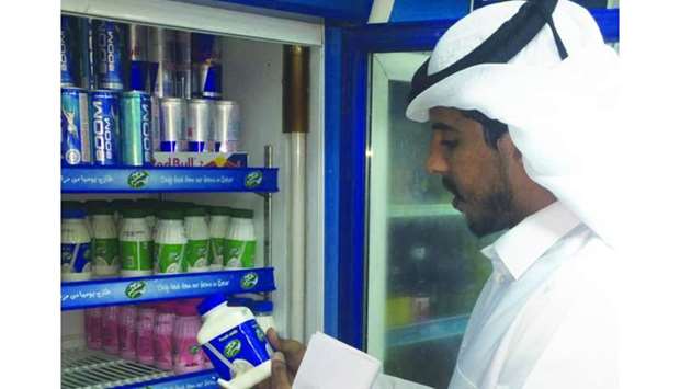 An inspector checks a label at a shop.