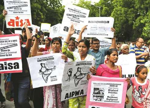 Activists and students hold placards as they shout slogans during a protest rally against the death of at least 64 children at a government hospital in Uttar Pradesh that suffered oxygen shortages, in New Delhi yesterday.