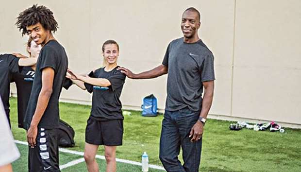 Olympic legend Michael Johnson (R) interacts with Generation Amazing Ambassador Reem Osman (2ndR) in Dallas, USA.