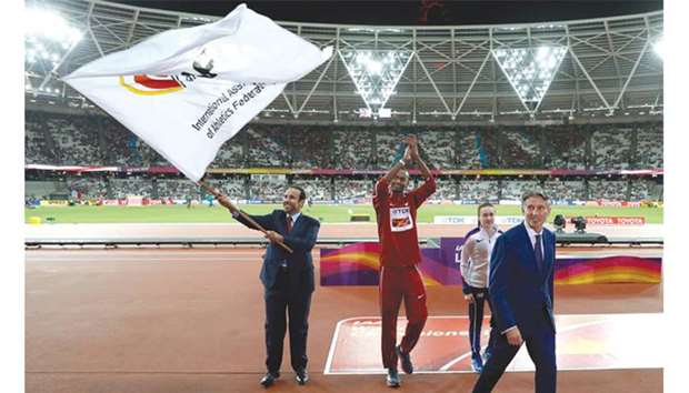 Dr Thani al-Kuwari, president of the Qatar Athletics Federation, waves the IAAF flag after receiving it from Sebastian Coe (right), president of the IAAF, at the London Stadium on Sunday.
