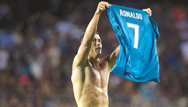 Real Madridu2019s Cristiano Ronaldo takes off his jersey to celebrate his goal against Barcelona during the Spanish Supercup match.