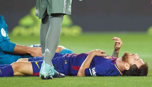 Barcelonau2019s Argentinian forward Lionel Messi lies on the field during the Spanish Supercup first leg match against Real Madrid.