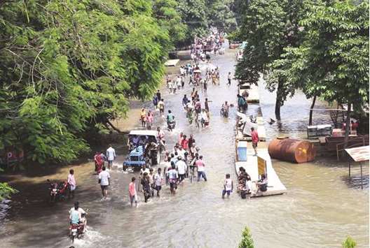 People wade through a flooded road in Araria district of Bihar yesterday.