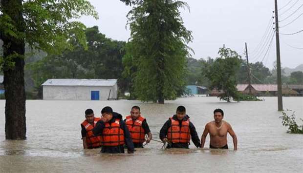 Nepali rescue workers walk with a resident through a flooded area at Sauraha Chitwan district, some 150kms south of Kathmandu, on Sunday.