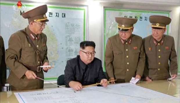 North Korean leader Kim Jong Un reviews the plan for landing missiles near the US territory of Guam in this undated still photo taken from video provided by KRT.