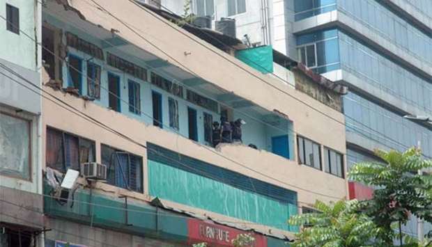 Bangladeshi police stand guard on the balcony of a hotel after a raid on a militant hideout in Dhaka on Tuesday.