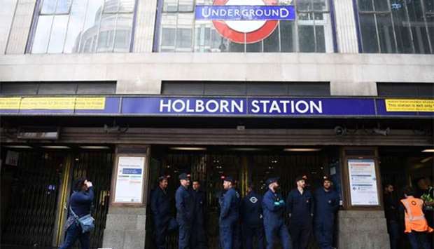 London Underground workers stand outside Holborn Station in London after it was temporarily closed following a fire alert on Tuesday.