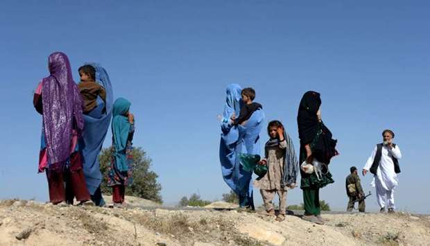 Afghan women with their children walk as they flee the area where US air forces targeted a civilian vehicle in Haska Mina district Nangarhar province on August 12, 2017.