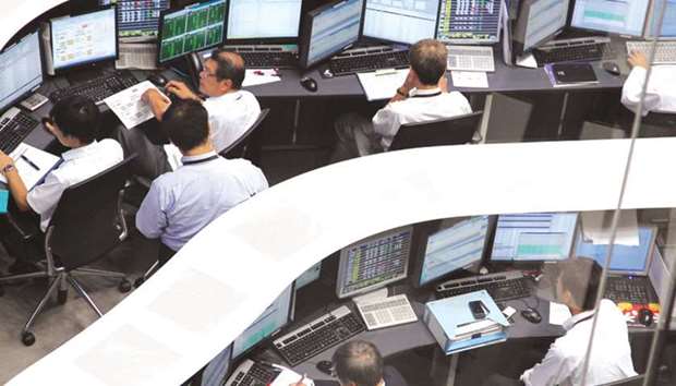Employees work at the Tokyo Stock Exchange. The Nikkei 225 closed up 1.1% to 19,753.31 points yesterday.