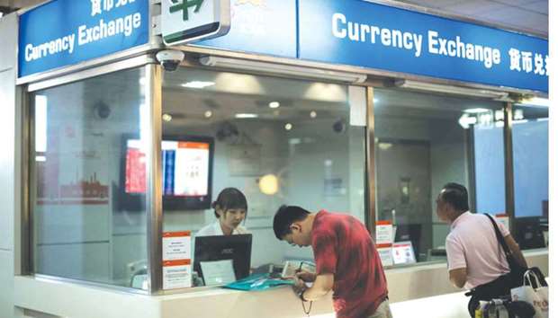 A man changes foreign currency into Chinese yuan at a currency exchange office in Hongqiao airport in Shanghai. China has given those who bet against the yuan a bloody nose this year thanks to policy moves and intervention by the authorities.