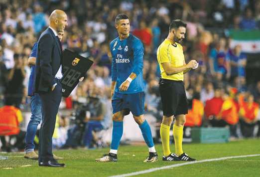 Real Madridu2019s Cristiano Ronaldo walks off dejected past coach Zinedine Zidane (left) after being sent off during the Spanish Super Cup first leg matcha against Barcelona on Sunday. (Reuters)