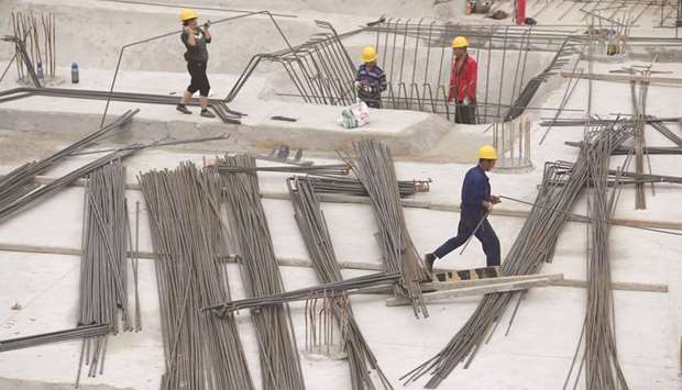 Labourers work at a construction site in Beijing. Growth in property investment in China, which mainly focuses on residential real estate but includes commercial and office space, eased to 4.8% in July from a year earlier, versus 7.9% in June, Reuters calculations based on official data showed yesterday.