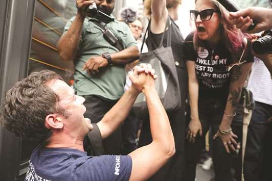 A President Donald Trump supporter argues with anti-Trump protesters as they gather outside of Trump Tower along Fifth Avenue.