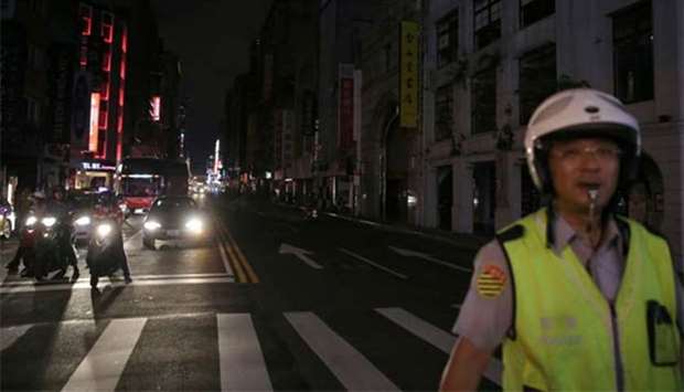 A policeman stands in front of a building during a massive power outage in Taipei.