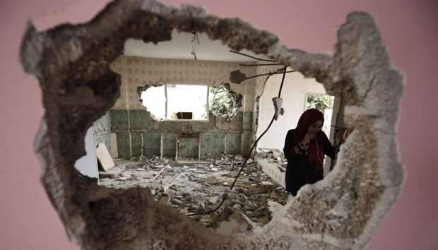 A woman checks the remains of the house of a Palestinian man, who killed three Jewish residents of a nearby Israeli settlement, after it was demolished by Israeli authorities in the West Bank village of Kobar, near Ramallah