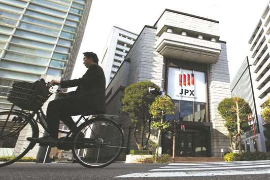 A man cycles past the Tokyo Stock Exchange. The Nikkei 225 closed down 0.1% to 19,729.28 points yesterday.