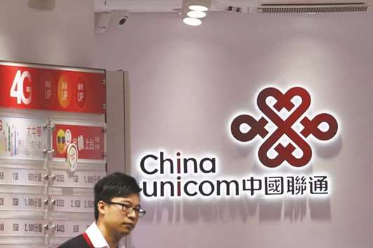 A salesperson of China Unicom waits for customers at a shop in Hong Kong. The Chinese government is seeking to rejuvenate state behemoths with private capital, with China Unicom among the first batch of state-owned enterprises slated for the mixed-ownership reforms.