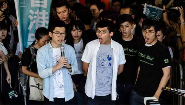 Nathan Law (left), Joshua Wong (centre) and Alex Chow, leaders of Hong Kong's 'Umbrella Movement', chant slogans as they address the media before their sentencing outside the High Court in Hong Kong on Thursday.