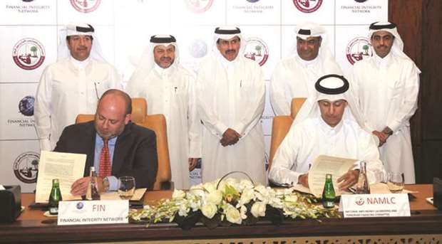HE Sheikh Fahad Faisal al-Thani, chairman of NAMLC and Deputy Governor of the Qatar Central Bank, and Daniel L Glaser, on behalf of FIN, sign the agreement in Doha yesterday as Qatar Central Bank Governor HE Sheikh Abdullah bin Saoud al-Thani and other officials look on. PICTURE: Shemeer Rasheed