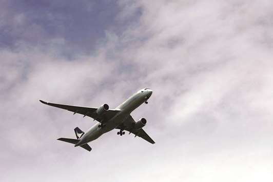 A Cathay Pacific passenger plane flies in Hong Kong. The carrier, in a briefing with analysts on Wednesday, said the corporate travel market was recovering and  passenger yields, a proxy for ticket prices, would see a smaller drop in the second half than the 5.2% fall in the first six months.