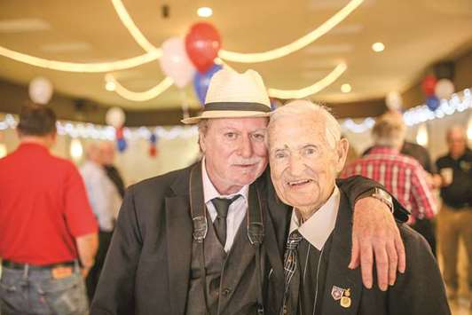 Tom Wearing takes a photo with his dad, John Wearing, during his life celebration at the Bruce VFW Post in St. Clair Shores.