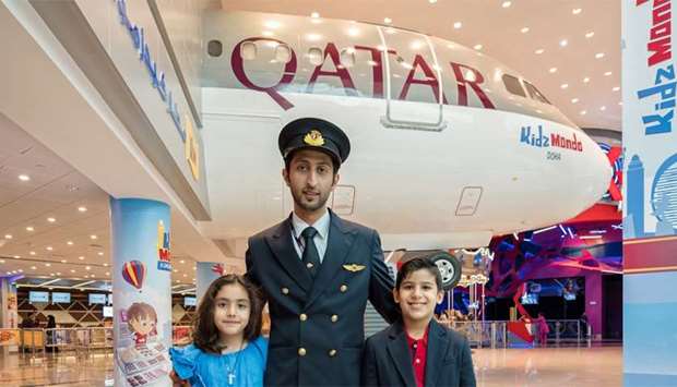 Qatar Airways' Qatari Captain Al Yafei Abdulaziz with eight year-old Maryam Mahasneh and eight year-old Bader Albanna