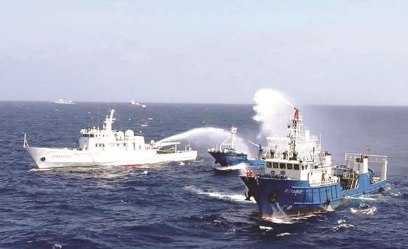 This photo taken on July 14, 2016 shows Chinese ships putting out a fire on a mock cargo vessel during an emergency drill in the South China Sea near Sansha, in south Chinau2019s Hainan province. Competing territorial claims u2013 mostly involving China  u2013 continue to stoke tension across Asia.