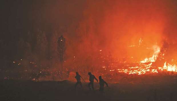 Firefighters tackle a wildfire at Vale de Abelha village in Macao.