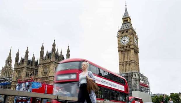 Big Ben is pictured as a red bus crosses the Westminster Bridge in London.
