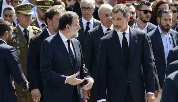 Spain's King Felipe VI (R) speaks with Spanish Prime Minister Mariano Rajoy as they leave after observing a minute of silence for the victims of the Barcelona attack at Plaza de Catalunya.
