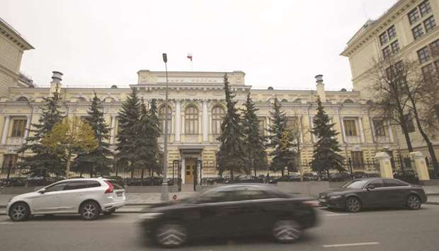 Vehicles pass in front of the headquarters of Russiau2019s central bank in Moscow. Good news for most Russians may be bad news for the central bank as it waits to resume  monetary easing after a pause in July.