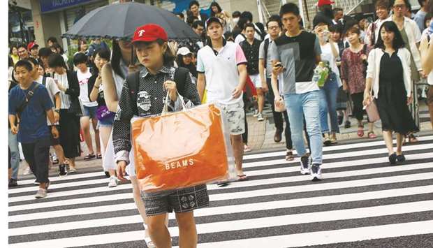 A woman carries a bag at a shopping district in Tokyo. Core consumer prices, available a month before the nationwide data, were seen likely to rise 0.3% in August from a year earlier after a 0.2% gain in July, according to economists polled by Reuters.