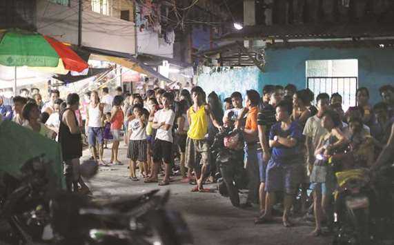 Residents gather along an alley after a police anti-drug operation in Caloocan city, Metro Manila, Philippines, August 17, 2017.