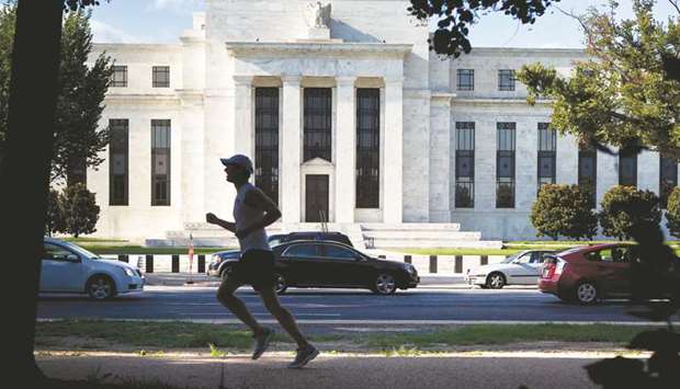 A runner passes the Federal Reserve building in Washington, DC. The stock marketu2019s steady rise, still low long-term bond yields and a sagging dollar are girding the Fedu2019s intent to raise interest rates again this year despite concerns about weak inflation,  according to comments this week from Fed officials and analysts anticipating remarks next week by Janet Yellen.