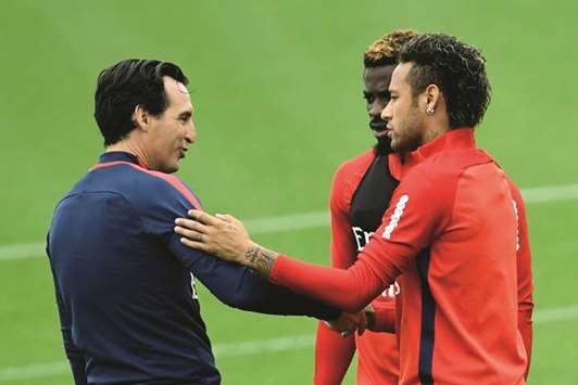 Paris Saint-Germainu2019s coach Unai Emery (left) greets forward Neymar during a training session. (AFP)