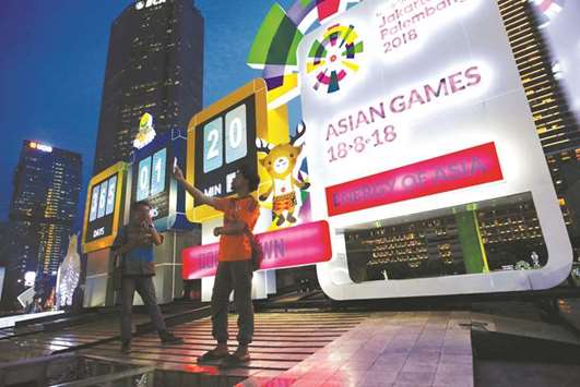 Workers take their picture next to countdown clock as Indonesia marks the one-year countdown before hosting the 2018 Asian Games in Jakarta yesterday. (Reuters)