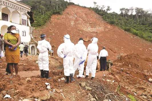 Volunteers inspect a partially-collapsed hillside yesterday in Freetown.