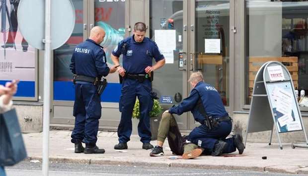 The suspect lies on the ground surrounded by police officers  in Turku