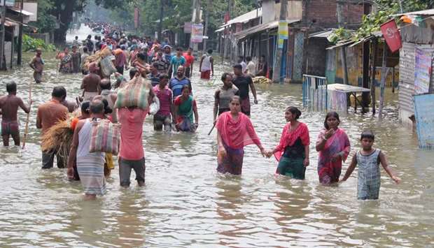 Indian residents wade through flood waters in Balurghat in West Bengal