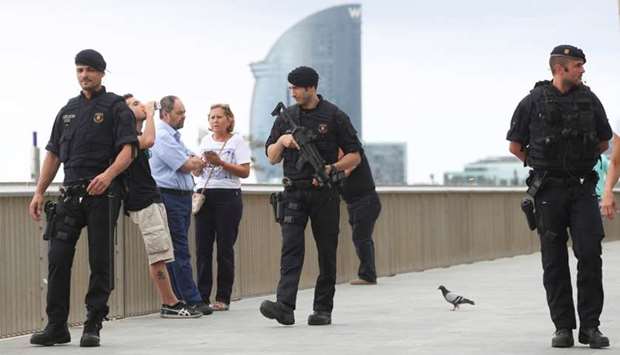 Armed officers patrol along La Barceloneta beach in Barcelona, Spain